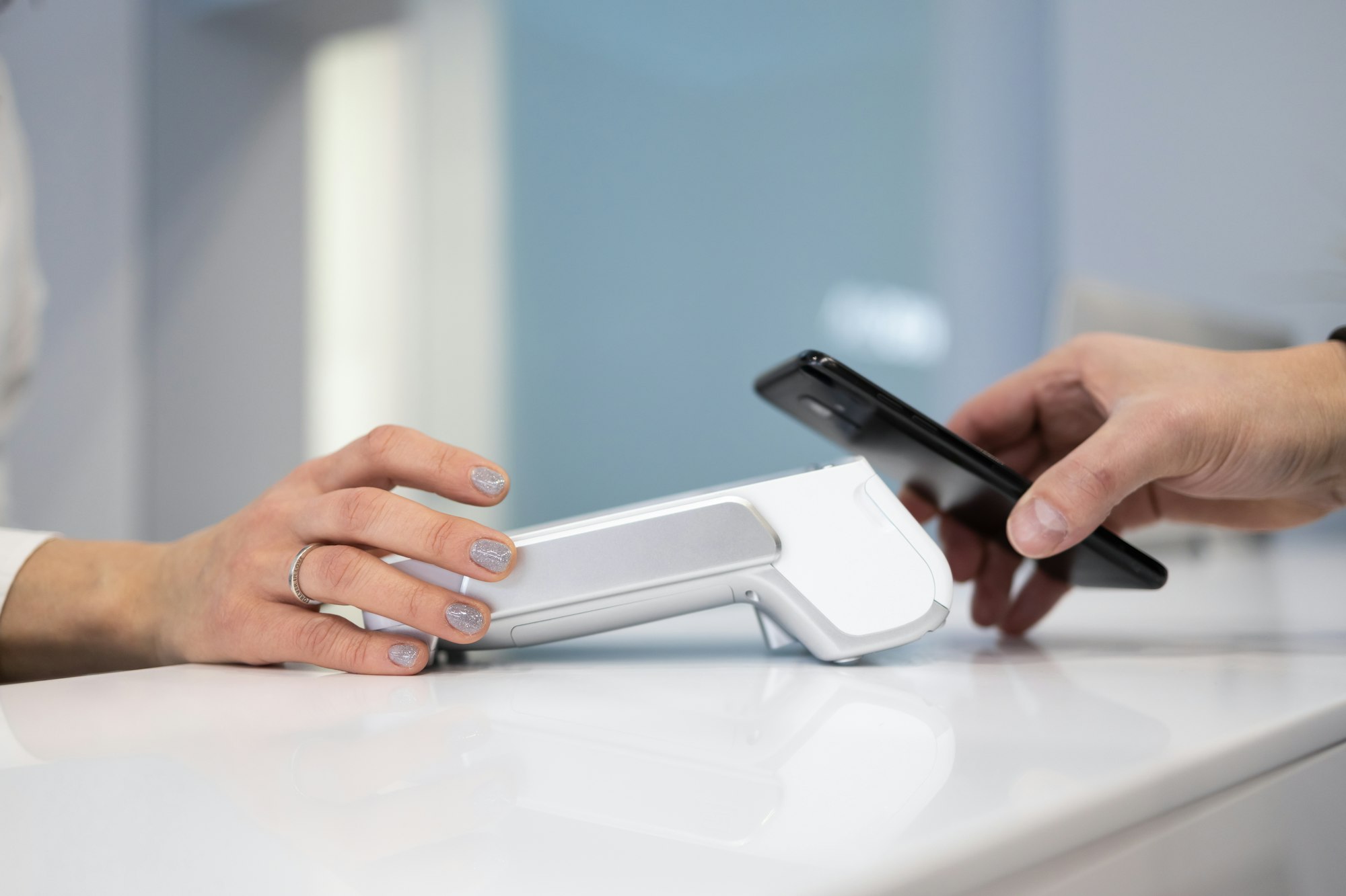 Customer paying by smartphone with NFC technology in POS terminal