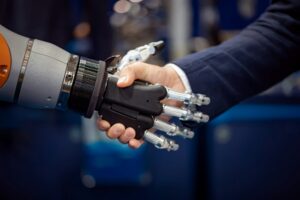 Hand of a businessman shaking hands with a Android robot.