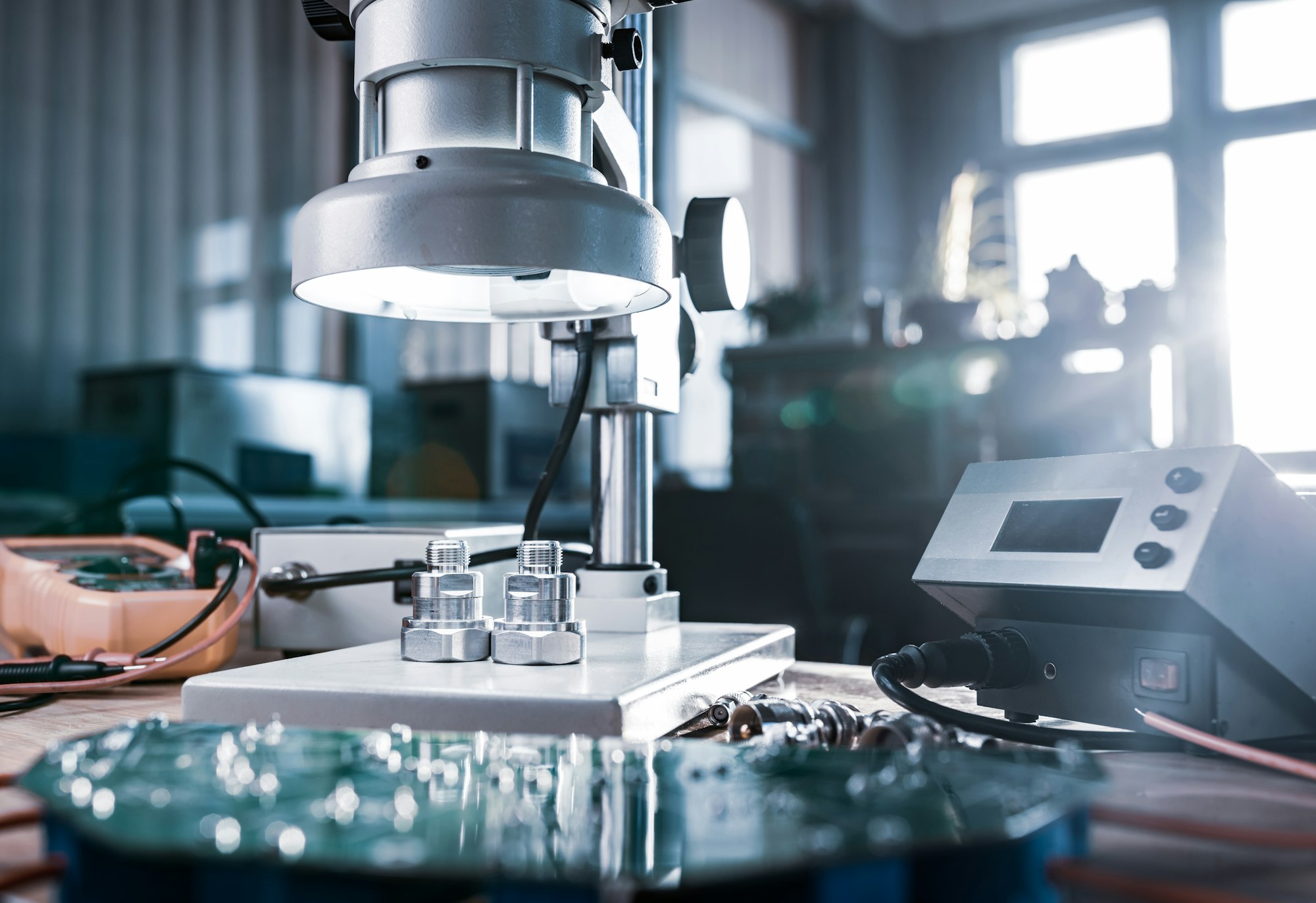 Modern microscope, connectors component and large green microcircuit in workshop laboratory